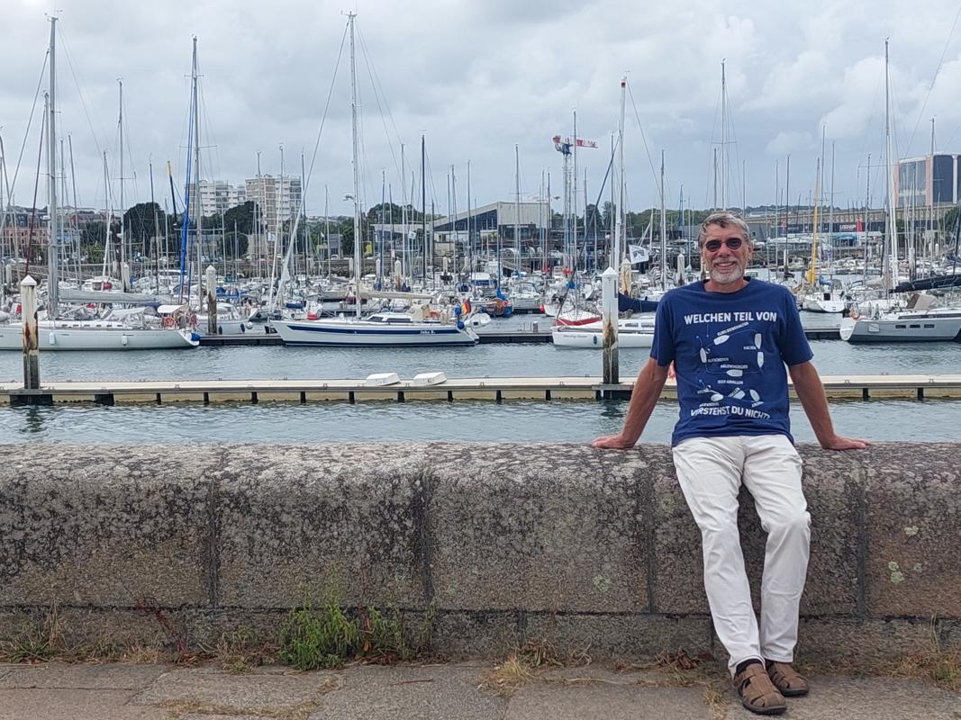 Skipper mit seinem Schiff im Rücken